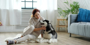 mulher com cachorro na sala de estar