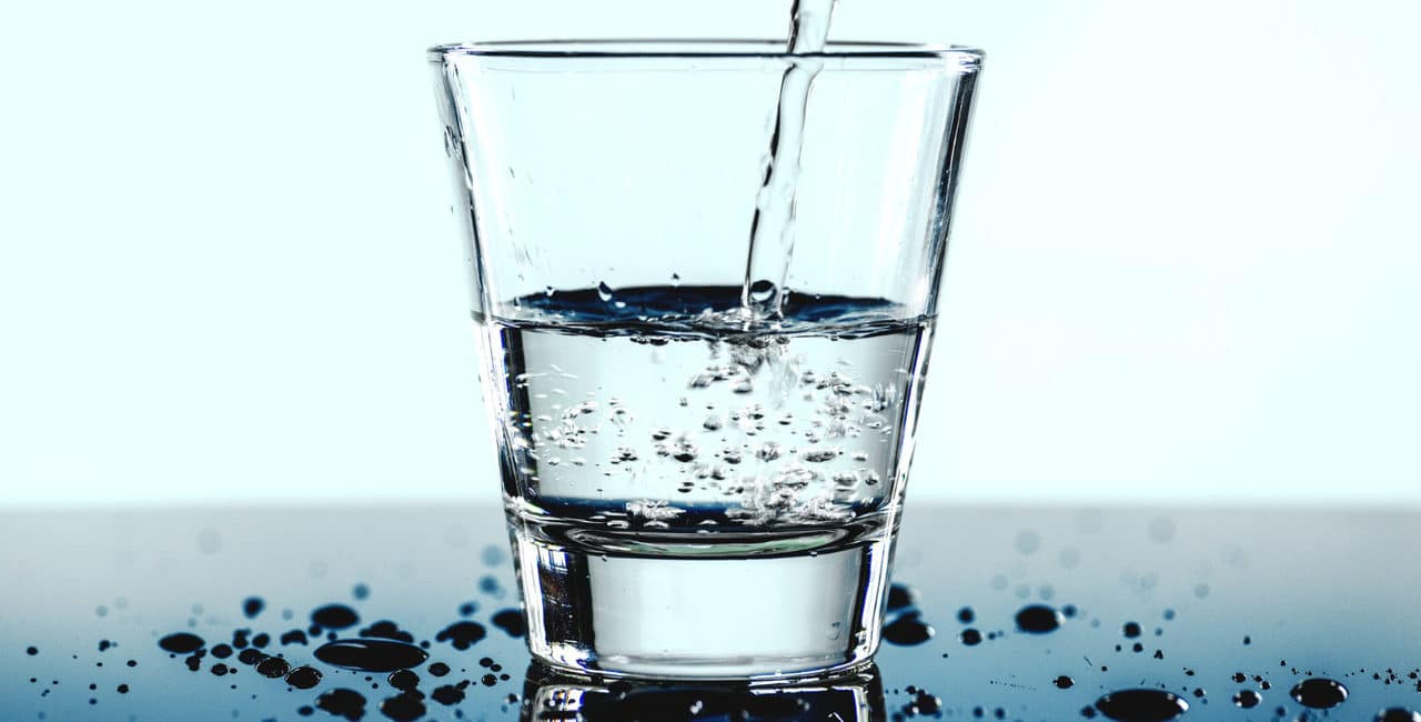 um copo com água sendo enchido para simbolizar o desperdício de água