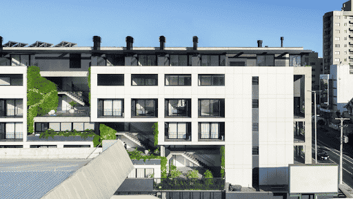 Imagem de um prédio com apartamentos com janelas de vidro e áreas verdes para simbolizar incorporação imobiliária