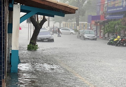 Imagem de uma rua alagada, com carros parados e chovendo para simbolizar a chuva em sao paulo