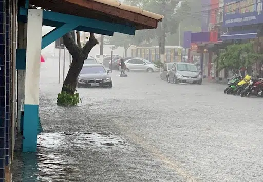 Imagem de uma rua alagada, com carros parados e chovendo para simbolizar a chuva em sao paulo